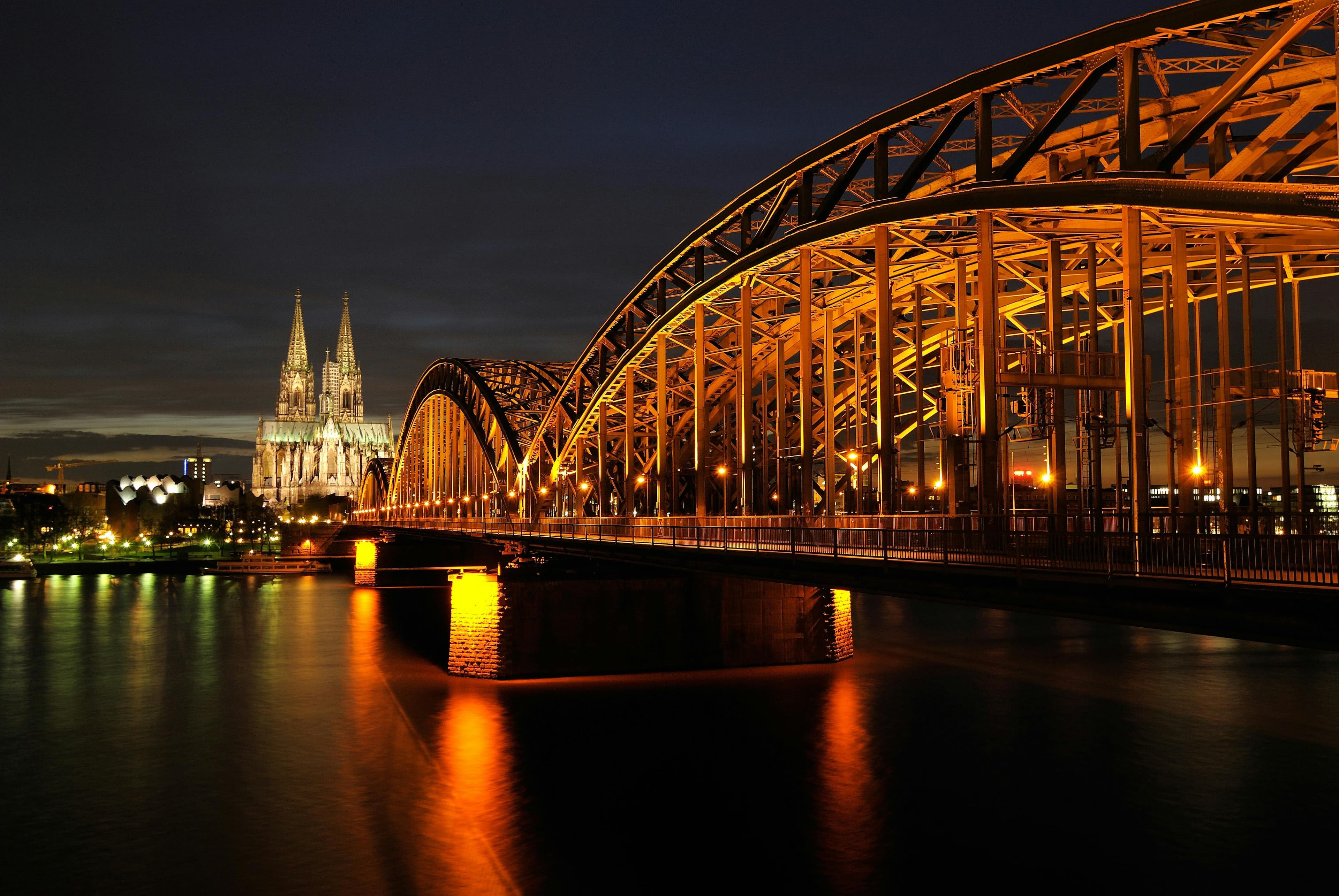 Blick auf eine Brücke über den Rhein in Köln mit dem Kölner Dom im Hintergrund.