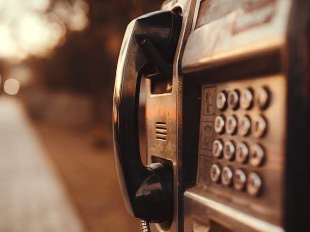 Aufnahme eines alten Münztelefons in der Abendsonne